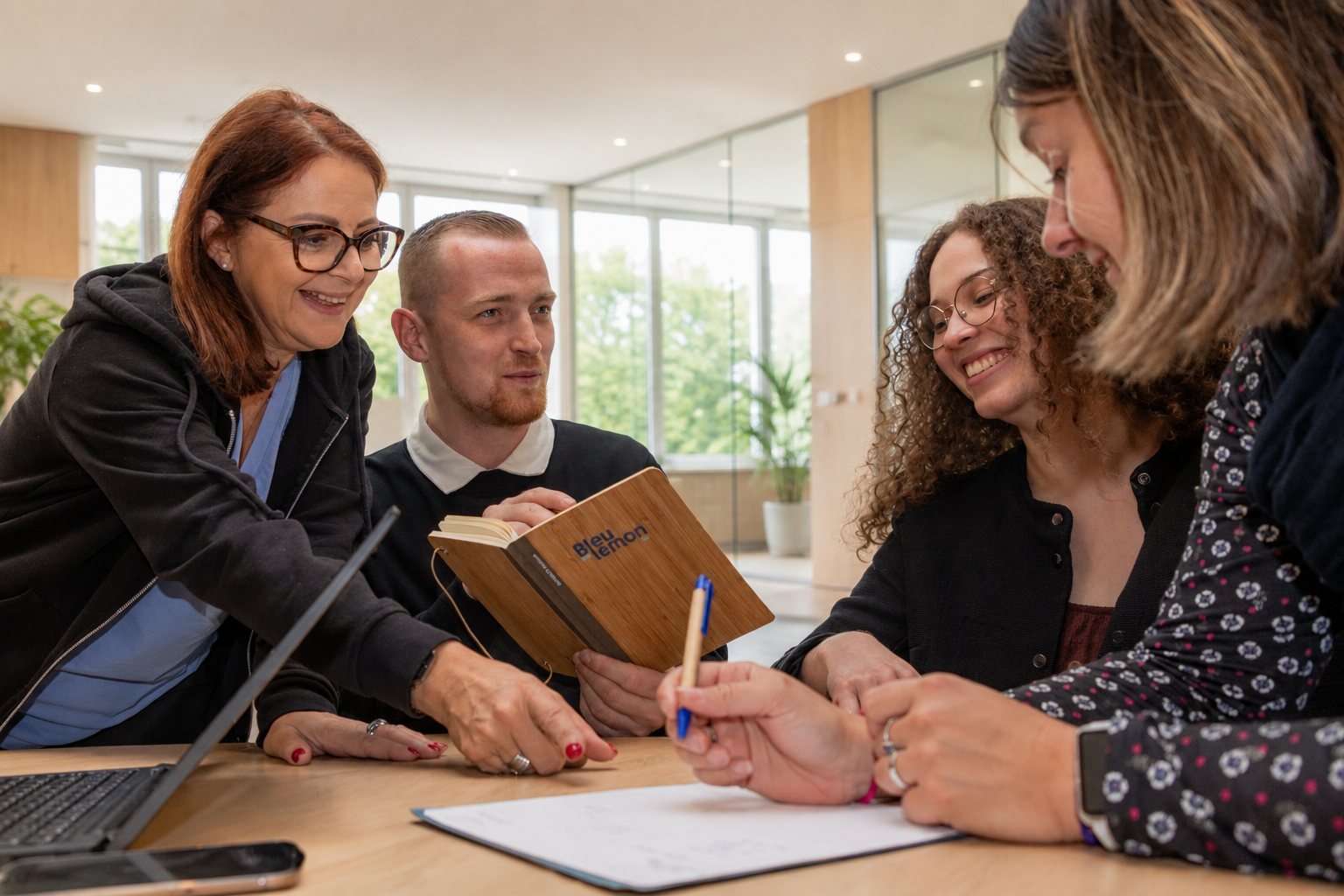 L'équipe réunie autour d'une table, carnet ouvert